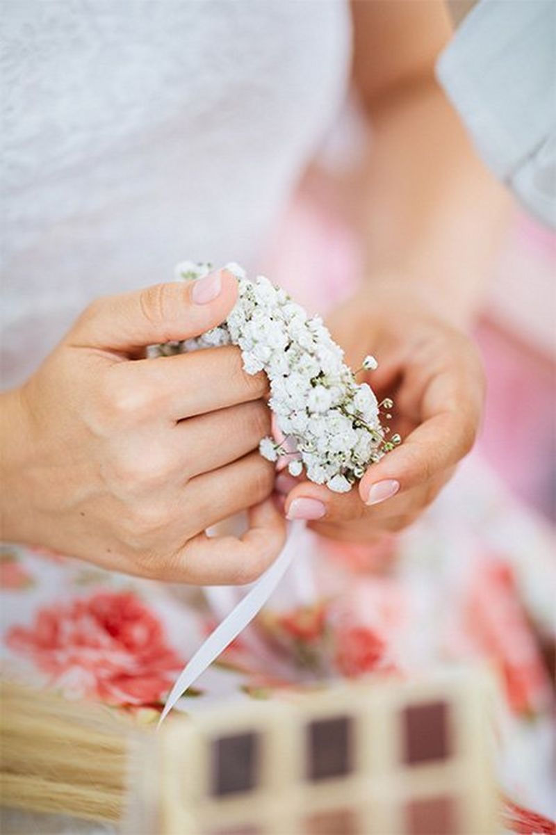 A close-up of hands holding bridal flowers.