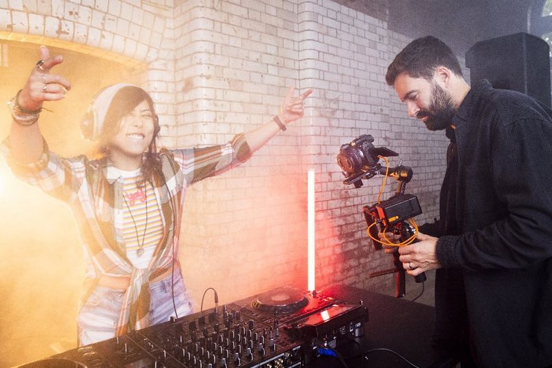 Ein Mann filmt einen DJ mit einem Canon VR-Objektiv