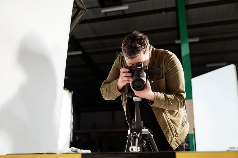 Сцена с различными товарами для дома, которые мужчина снимает на камеру Canon EOS R6 с объективом Canon RF24-70mm F2.8 L IS USM.