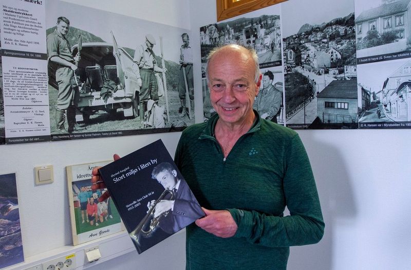 Øyvind Aasgård står med en bok