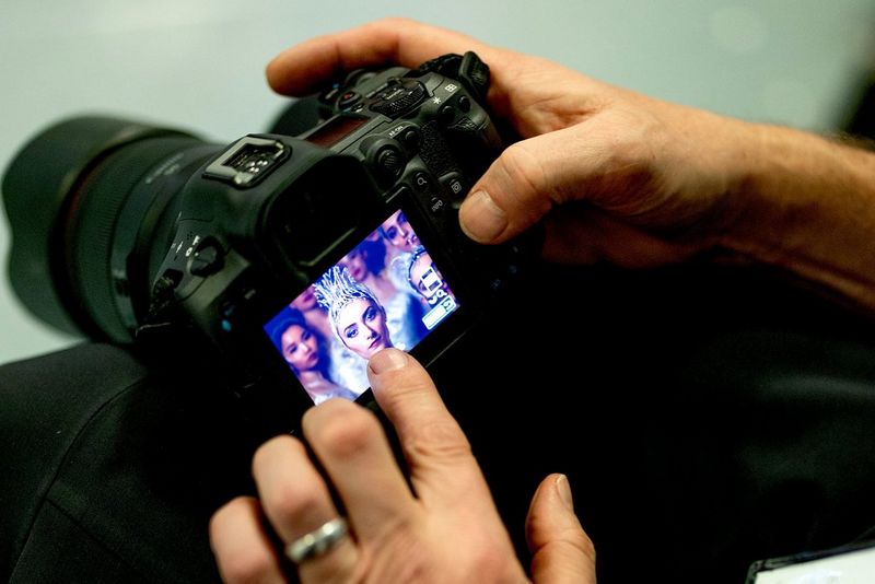 Крупный план: на LCD-экране камеры EOS R5 Mark II застыло лицо балерины, на которое указывает указательный палец.