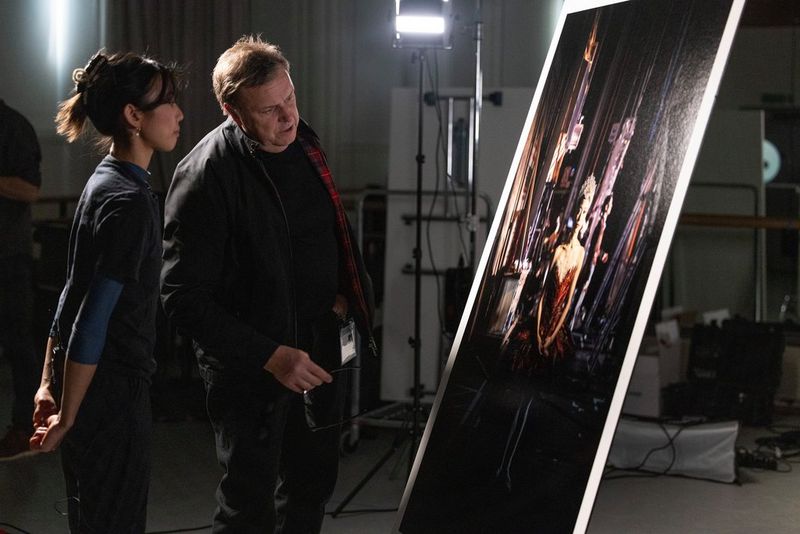 Женщина и фотограф Клайв Бут замерли у портрета балерины в алой пачке.