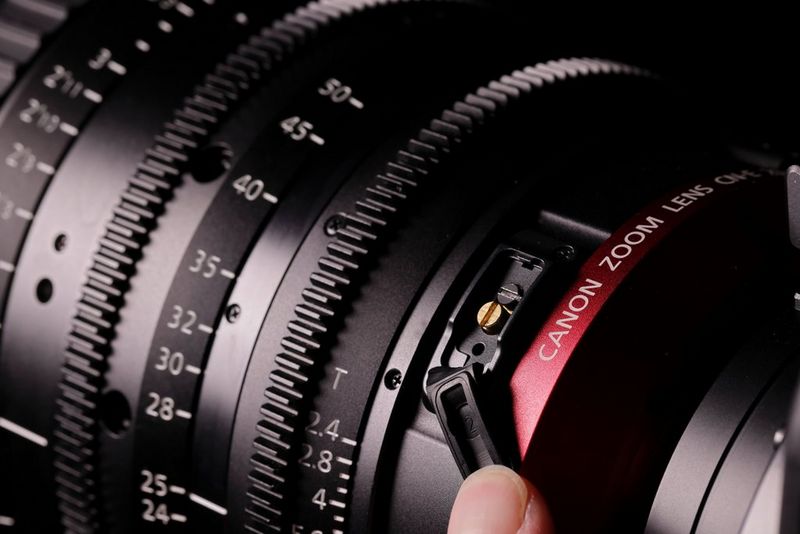 Человек держит пальцем резиновый фланец на задней части объектива Canon Flex Zoom, демонстрируя подстройку заднего отрезка.