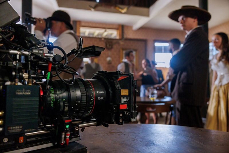 Камера Canon Cinema EOS с объективом Flex Zoom на столе в баре, оформленном в стиле вестерн.