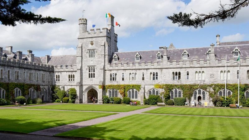 A panorama of the buildings of University College Cork in Ireland, set against a blue but cloudy sky.