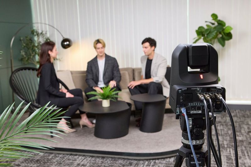 A Canon CR-N400 PTZ camera filming three people conducting an interview on a settee.