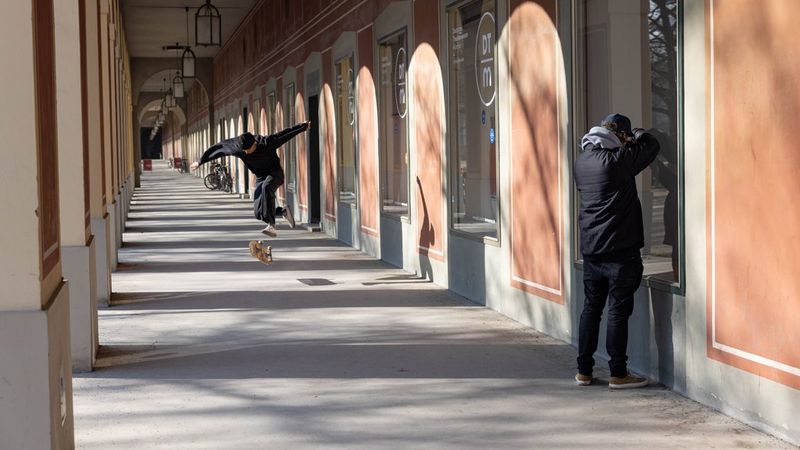Лоренц Холдер фотографирует скейтбордиста во время уличного катания в Германии, а сбоку арки колоннады отбрасывают разные тени на стену.