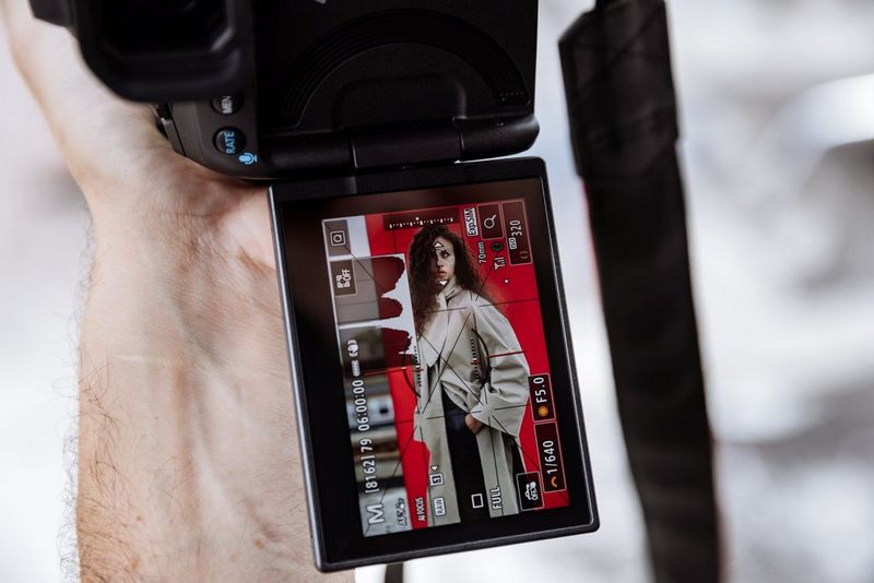 The vari-angle screen of a Canon EOS R5 Mark II camera showing a model photo with copious information displayed, including the image histogram.