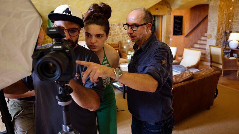 Photojournalist Paolo Verzone, a mentor at the Canon Student Development Programme 2024 shows a man and woman details on the back of a Canon EOS R System camera. 
