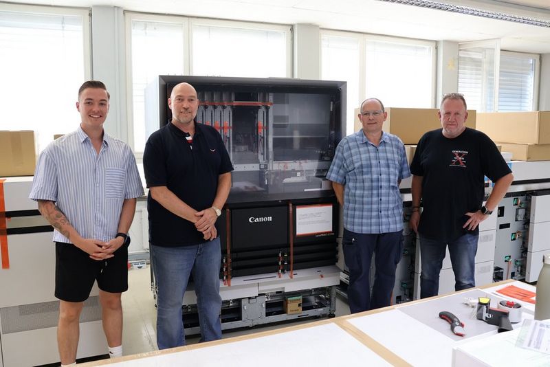 Image shows AC medienhaus personnel in front of newly installed Canon varioPRINT iX1700. For details of each individual shown, please see the end of the press release.