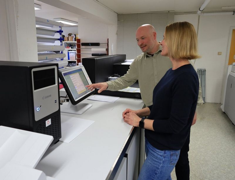 Daglig leder Erlend Bakken viser Anita Vistnes Bakken menyen i PRISMAsync