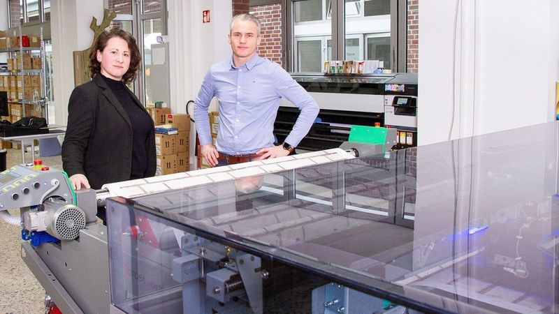 Man and woman in front of printer