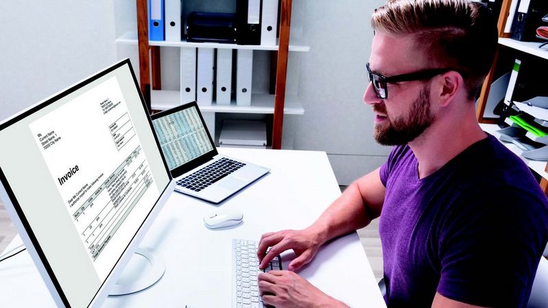 Man sitting at a desk looking at a monitor