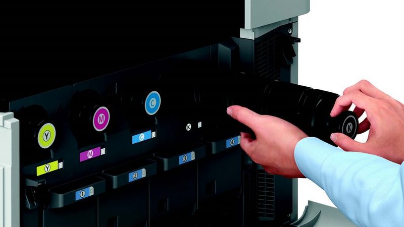 Hands replacing a cartridge in a printer