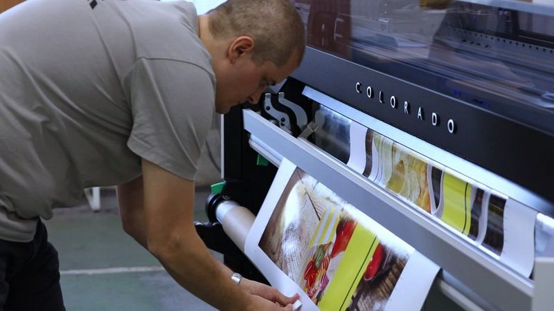 Picture of man using a Colorado roll-to-roll printer at Dekor