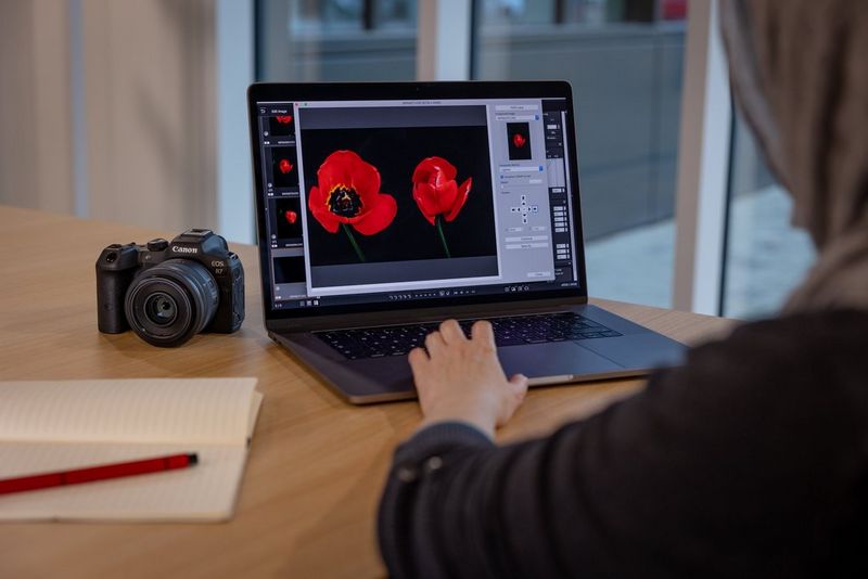 Un'inquadratura di quinta di un utente con il software Digital Photo Professional su un computer portatile, con una fotocamera Canon EOS R7 sulla scrivania accanto.