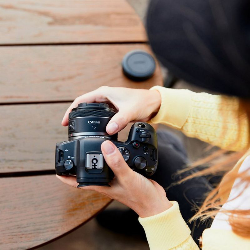 Person, die das RF 16mm F2.8 STM Objektiv an einer Canon Kamera anbringt.