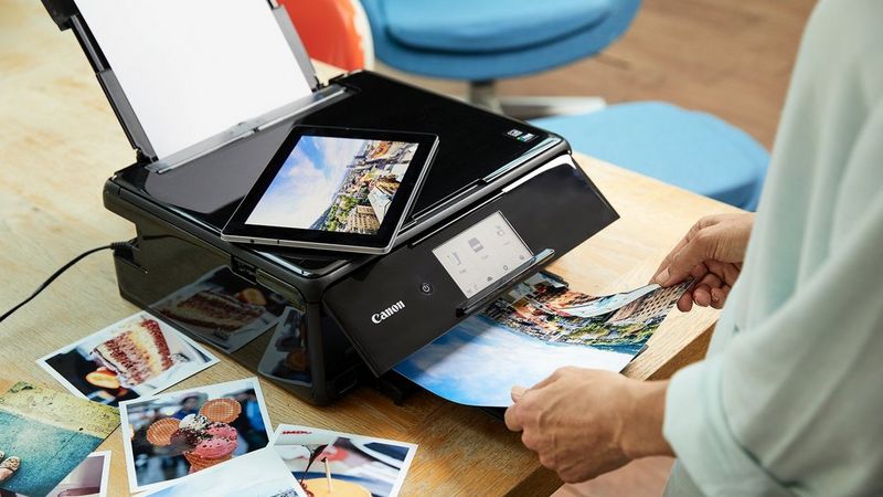 Eine Person verwendet die Canon Print App auf ihrem Tablet, um lebendige Fotos mit einem PIXMA Drucker auszudrucken.