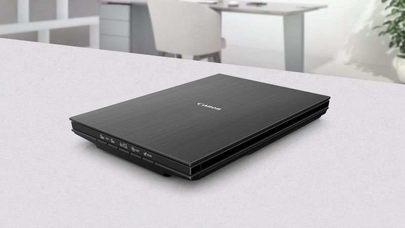Canon CanoScan LiDE 400 Flachbettscanner auf einem Schreibtisch an einem aufgeräumten Büroarbeitsplatz.