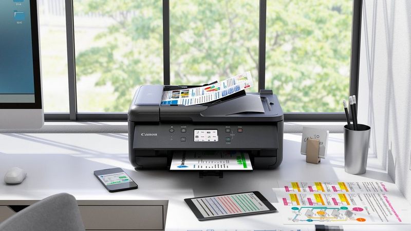 Canon PIXMA TR7650 Drucker auf einem Schreibtisch im Homeoffice beim Drucken von Dokumenten neben Schreibwaren und Karten.