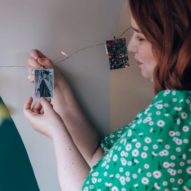 Woman posting up polaroid photos