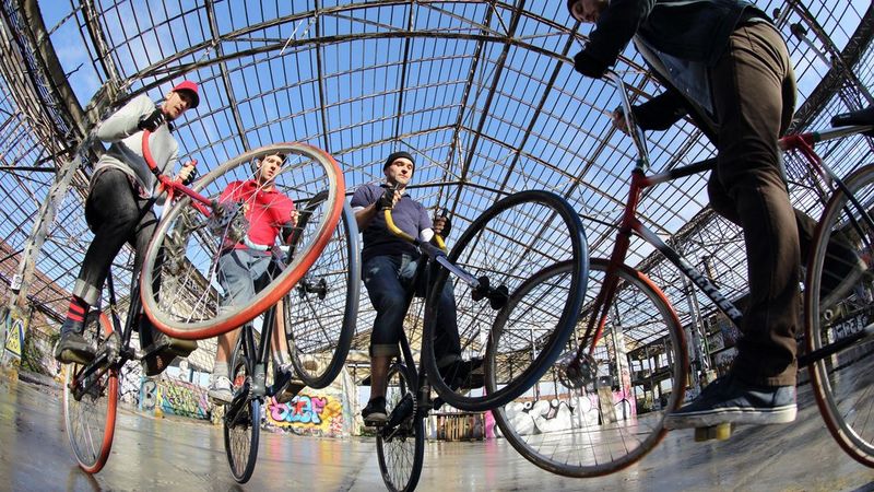 Quattro ciclisti in piedi sulle ruote posteriori. Scatto realizzato con un obiettivo Canon EF 8-15mm f/4 L Fisheye USM.