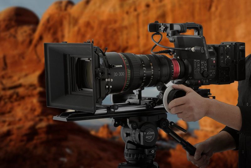 A Canon EOS C500 Mark II camera being operated in rocky terrain.