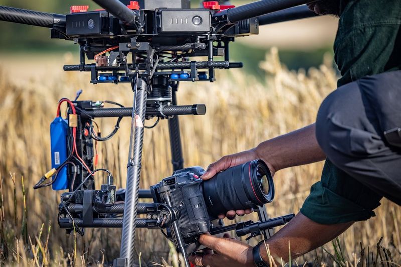 A man attaches a Canon EOS C70 cinema camera to a drone.