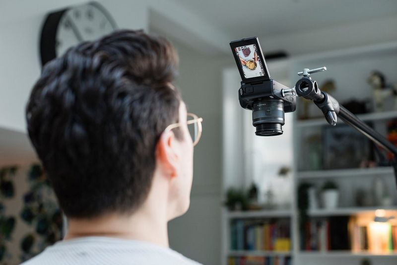 Matt Adlard gleda v vrtljivi zaslon fotoaparata Canon EOS M50 Mark II. Fotoaparat je nameščen na stojalo in usmerjen navzdol za ustvarjanje posnetkov iz ptičje perspektive.