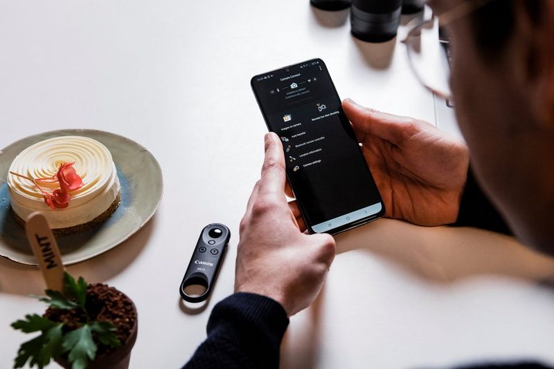 Matt Adlard drži telefon poleg mete in majhne skutne torte na kuhinjskem pultu.