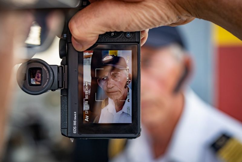 Задний экран камеры Canon EOS M6 Mark II, выполняющей автофокусировку на лице и глазах человека в синей бейсболке.