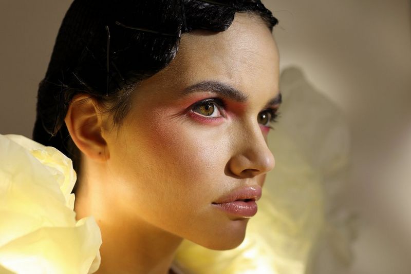 Krupni plan bočnog profila glave modela sa sjajnim ružom i ružičastom šminkom.