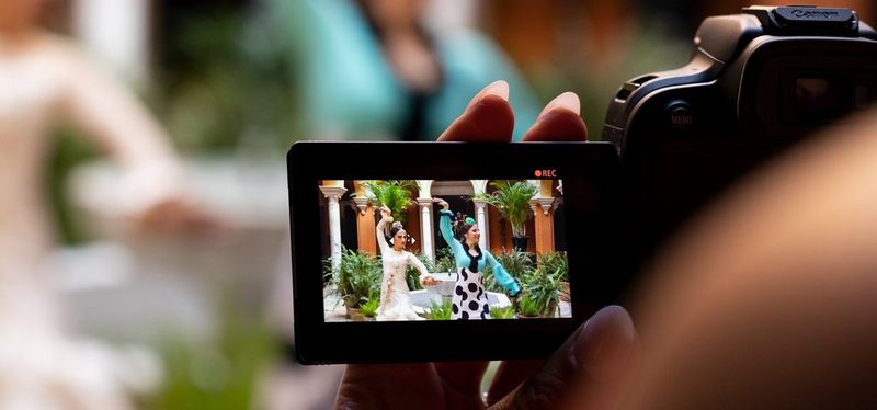 Een blik over de schouder van een fotograaf op het LCD-scherm van een Canon EOS R10, waarop twee flamencodansers te zien zijn die worden gefilmd.