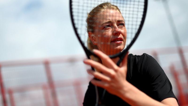 Теннисистка крупным планом, лицо которой видно сквозь сетку ее ракетки; снято на Canon EOS R1, что подчеркивает возможность системы автофокусировки на этой камере распознавать человеческие лица даже через сетки с разным размером ячейки.