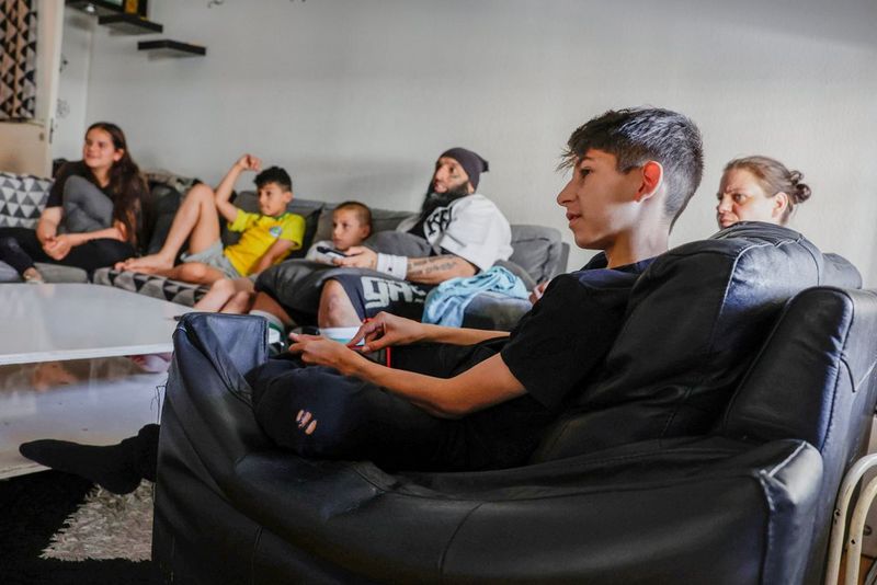 Een gezin ontspant op twee banken om een salontafel.