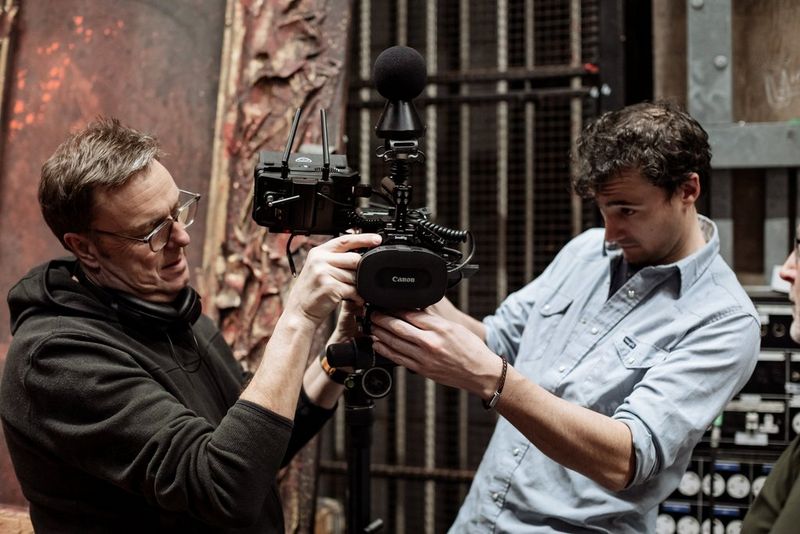 Clive Booth en Tom Rogers staan aan weerszijden van een Canon EOS R5 C met een Canon RF 5.2mm F2.8L DUAL FISHEYE-lens en zijn de opstelling aan het aanpassen.