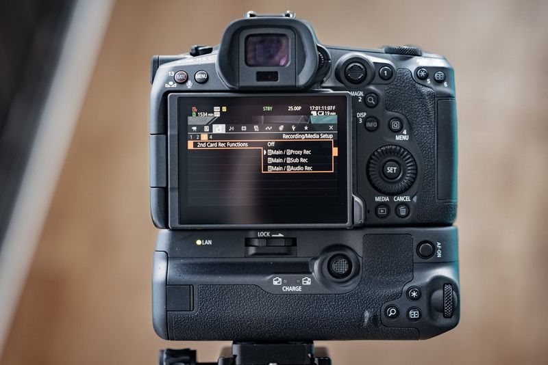 De achterkant van een Canon EOS R5 C op een statief, met het menuscherm voor opnamefuncties van de tweede kaart.