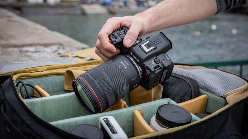 Een man haalt een Canon EOS R5 C met een Canon RF 24-70mm F2.8L IS USM-objectief uit een cameratas.