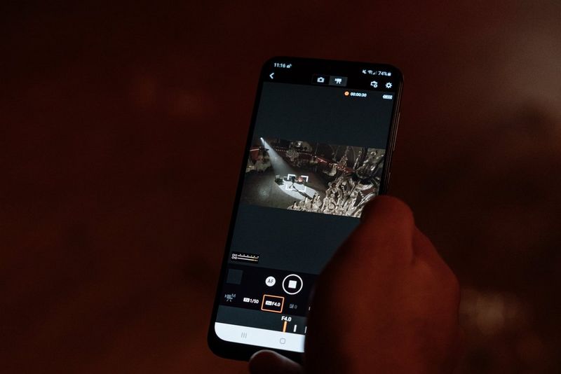 Een hand met daarin een smartphone met videobeelden op het scherm.