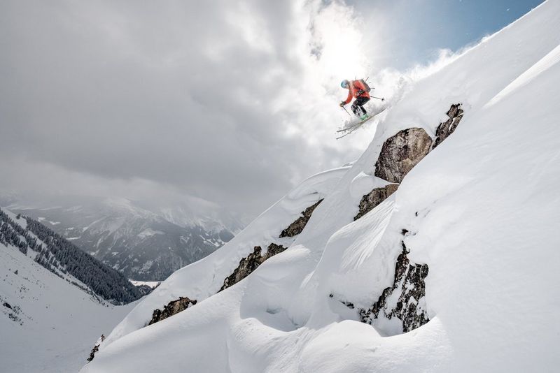 A skier coming down a run, backlit by the sun and photographed using a wide-angle lens.