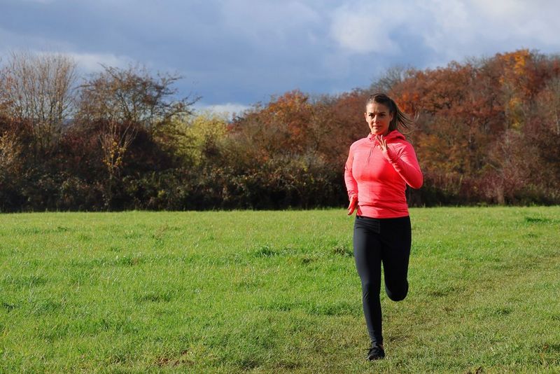 רץ בלבוש עליון אדום, שצולם מימין למרכז המסגרת כשהוא רץ בשדה פתוח לעבר המצלמה ומאחוריו שורת עצים.