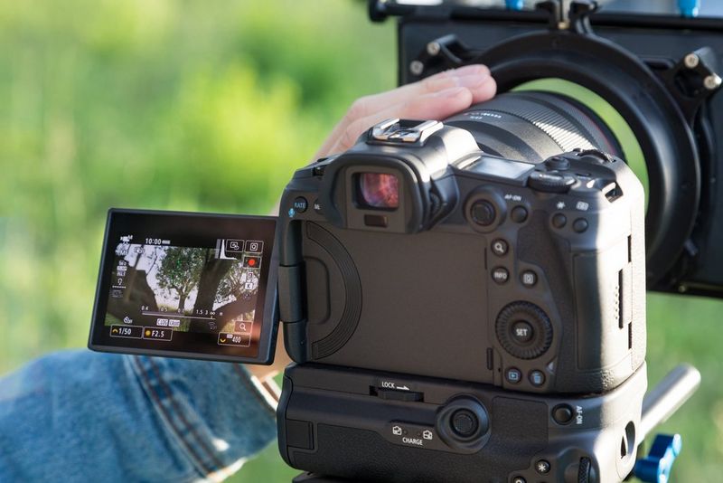 A Canon EOS R5 mounted on a tripod with the touchscreen flipped out.