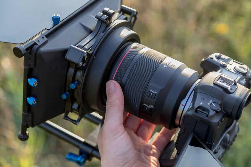 A hand on a Canon RF 50mm F1.2L USM lens attached to a Canon EOS R5.