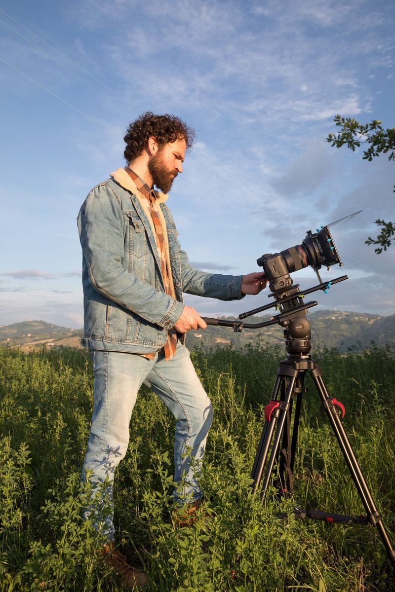 Filmmaker Ivan D'Antonio stands behind a tripod mounted with a Canon EOS R5.