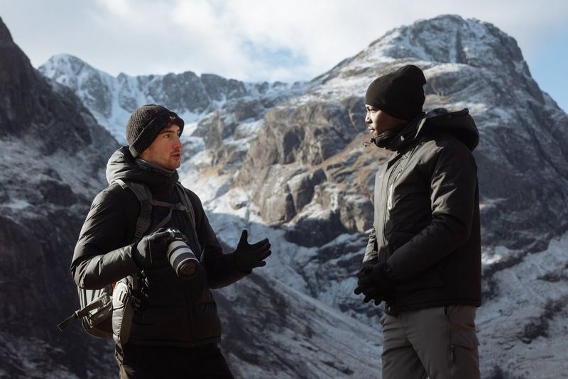 Harrison Brown e Tomi Adebayo che discutono della creazione di contenuti con una montagna innevata sullo sfondo.