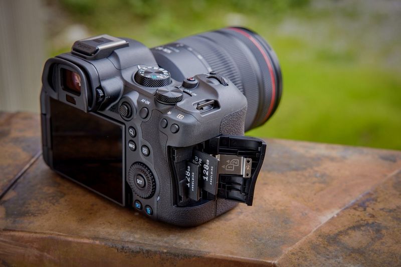 Een Canon EOS R6 Mark II gefotografeerd van de zijkant. De klep aan de zijkant is open om de twee kaartsleuven te tonen.