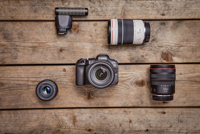 Le Canon EOS R6 Mark II posé sur une table en bois avec différents objectifs.