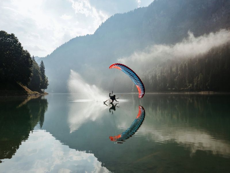 Photo de sport prise avec un Canon EOS R6 Mark II équipé d'un objectif Canon RF 24-105mm F4L IS USM d'un speed flyer heurtant la surface d'un lac, son reflet visible à la surface de l'eau.