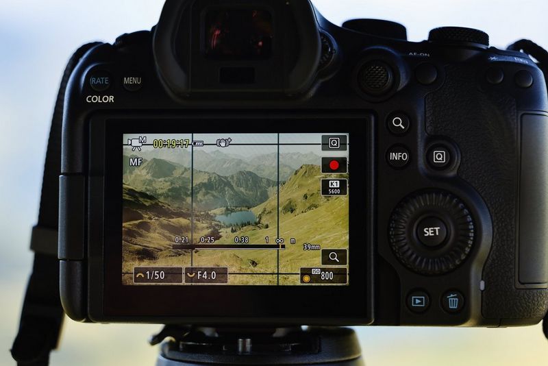 The rear screen of a Canon EOS R6 Mark III displaying Open Gate video mode with a landscape scene and two clearly marked aspect ratio overlays.