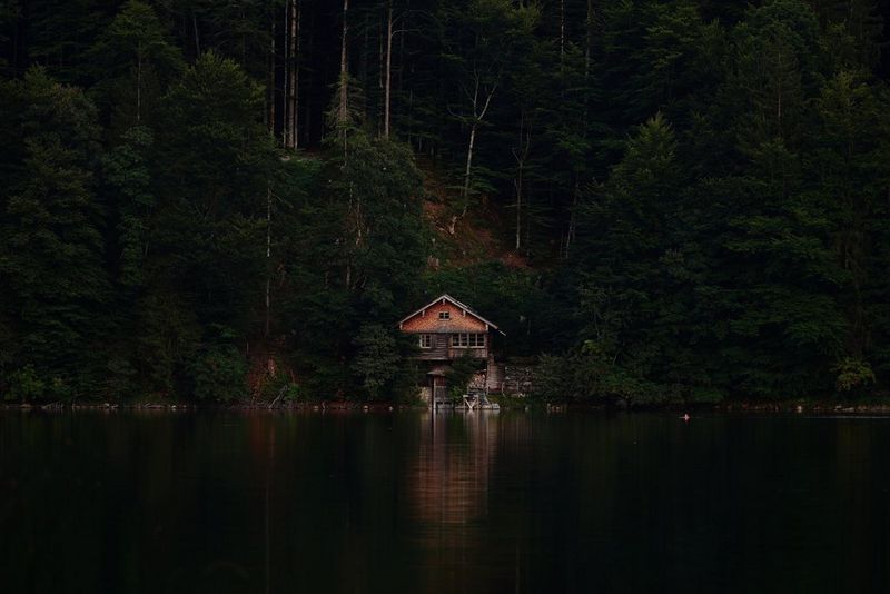 A building next to a lake in a forest, captured in low light with the Canon EOS R6 Mark III.